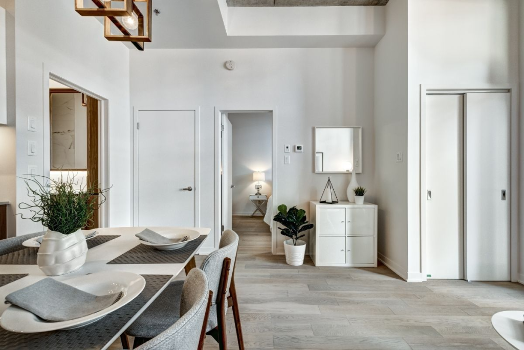 A modern dining area with a wooden table, white chairs, and fresh decor, reflecting the results of Apartment Sanitization Service in keeping the space polished and germ-free.