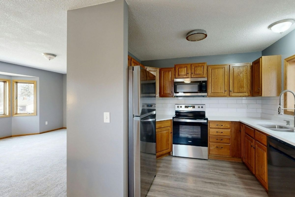 Cozy modern kitchen with stainless steel appliances and dining area demonstrating the benefits of routine appliance cleaning.