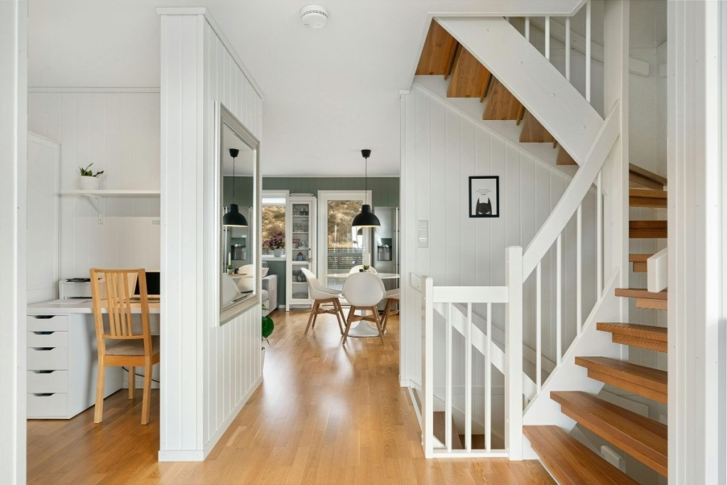 Modern home interior with wooden staircase, desk, and dining area organized using practical Weekend Cleaning Hacks.