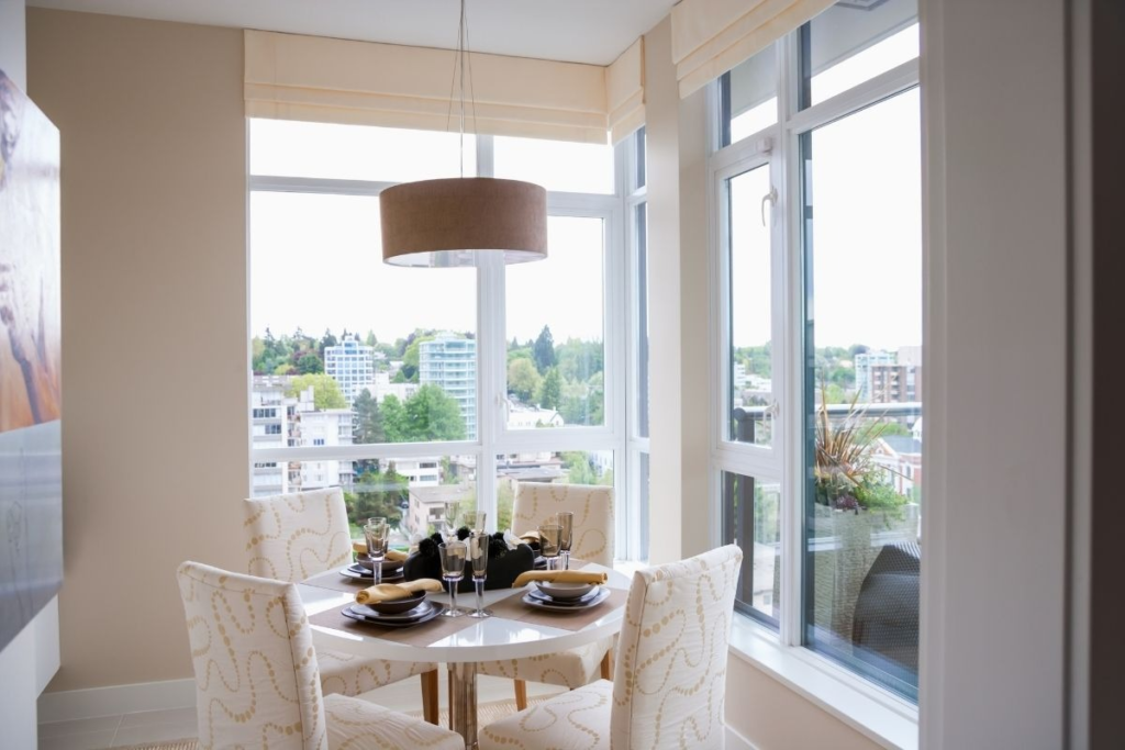 Sunlit dining room with city views, professionally maintained by eco-cleaning services for a healthy home.