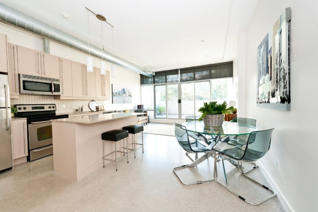 Industrial loft kitchen and glass dining table kept allergen-free with professional eco-cleaning services.