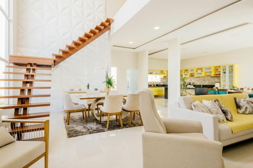 Open plan home with stairs and yellow kitchen; large airy spaces where dust returns after cleaning.